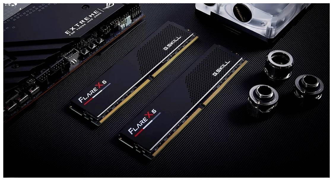 Dwa moduły RAM marki 'Flare X5' leżą na ciemnym tle, otoczone elementami komputerowymi, takimi jak złącza i radiator.