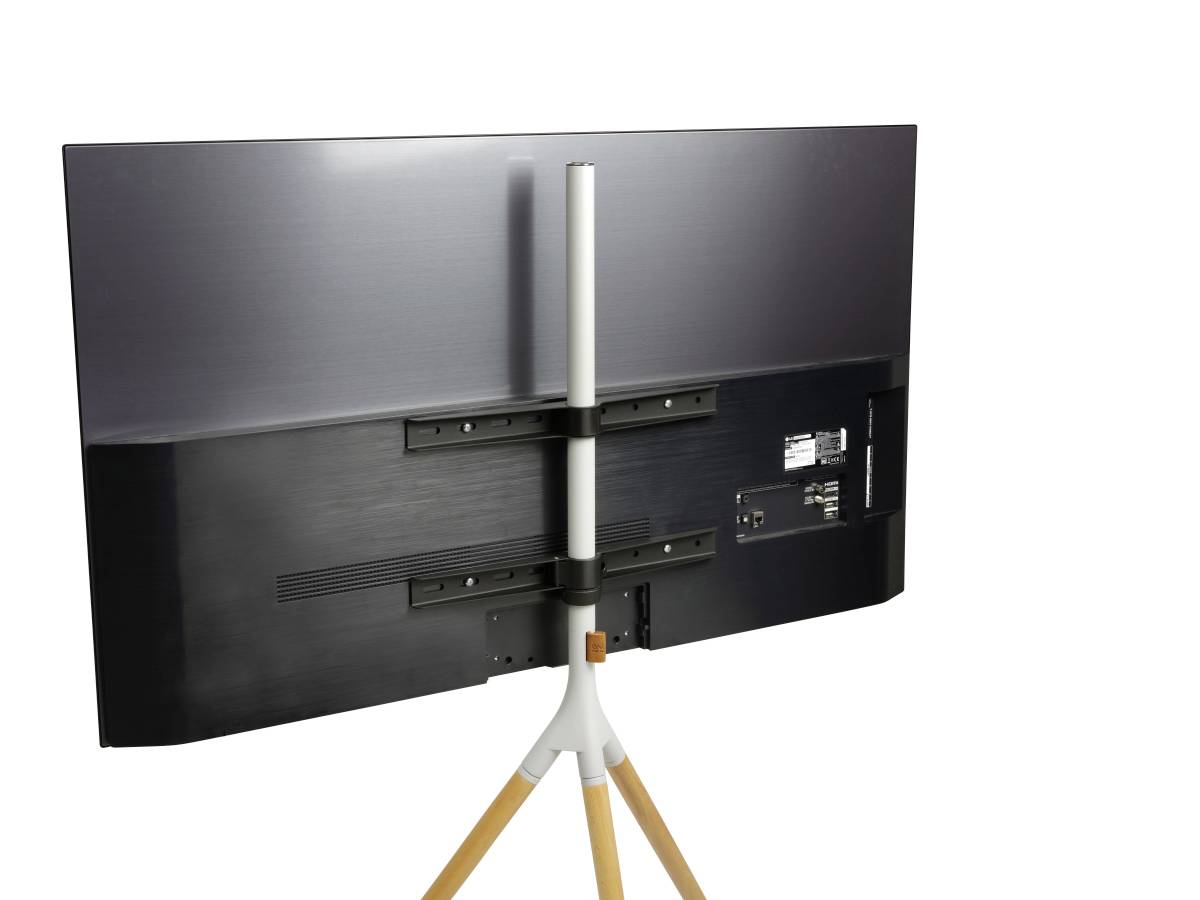 Płaski telewizor widziany od tyłu, umieszczony na statywie z drewnianymi nogami, w czarnej obudowie, z widocznymi złączami kablowymi.
