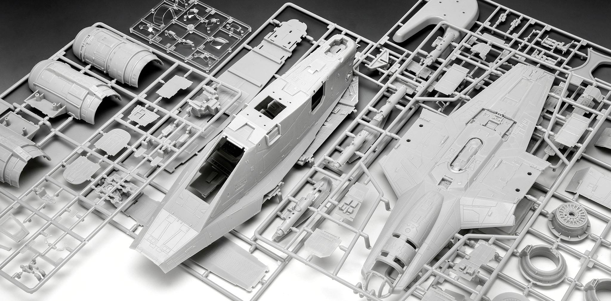 Zestaw modelarski samolotu z tworzywa sztucznego, prezentujący poszczególne elementy, takie jak kadłub i skrzydła na wkładkach siatkowych, gotowy do złożenia.