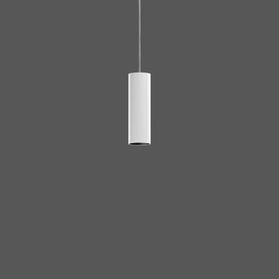 Biała, cylindryczna lampa wisząca zwiesza się z sufitu na szarym tle.