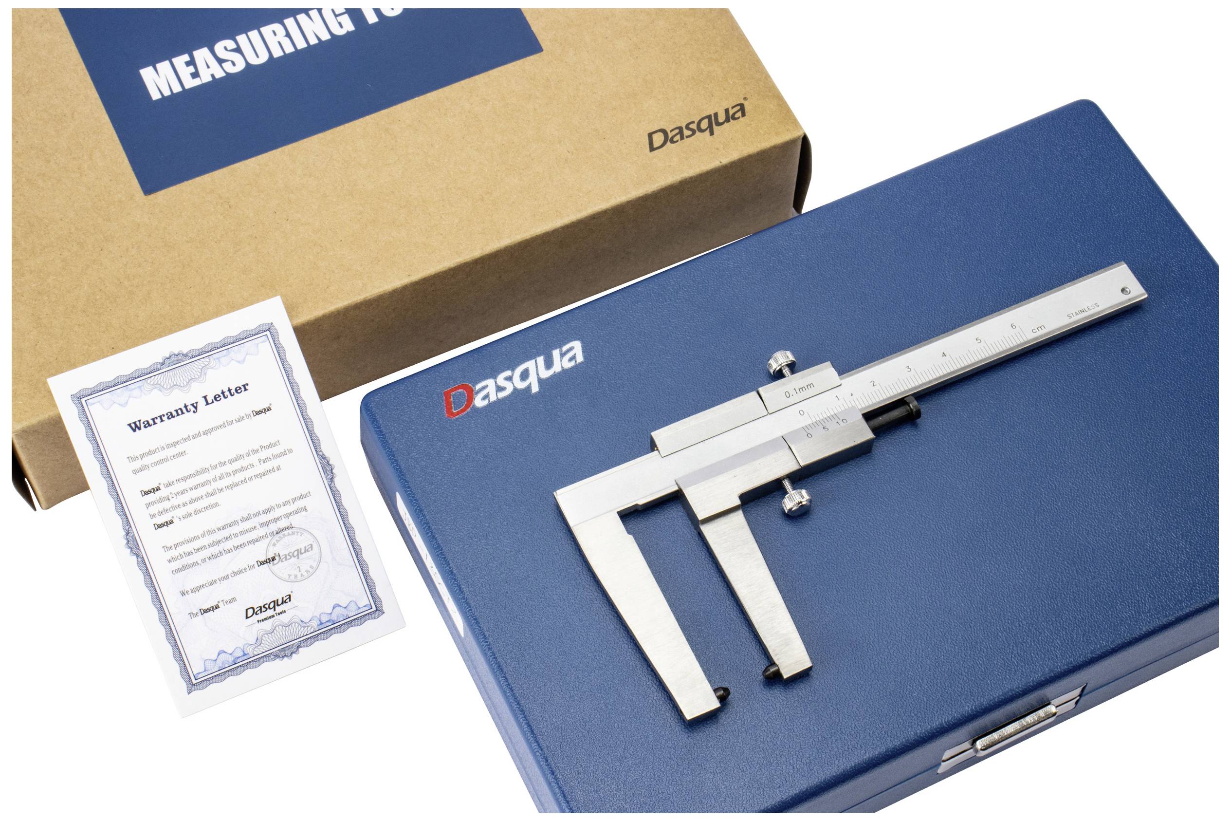 Suwmiarka ze stali nierdzewnej leży na niebieskiej obudowie, obok niej znajduje się certyfikat gwarancyjny i brązowe pudełko z napisem 'Measuring Tool'.