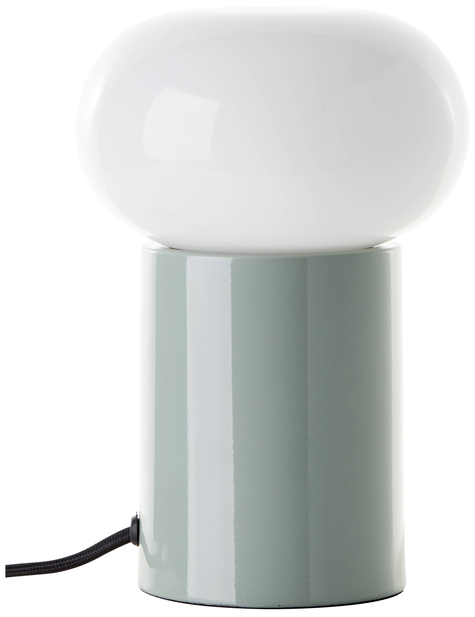 Biała lampa stołowa z okrągłym, błyszczącym kloszem i cylindryczną, zieloną podstawą stoi na podłożu. Czarny kabel jest widoczny.