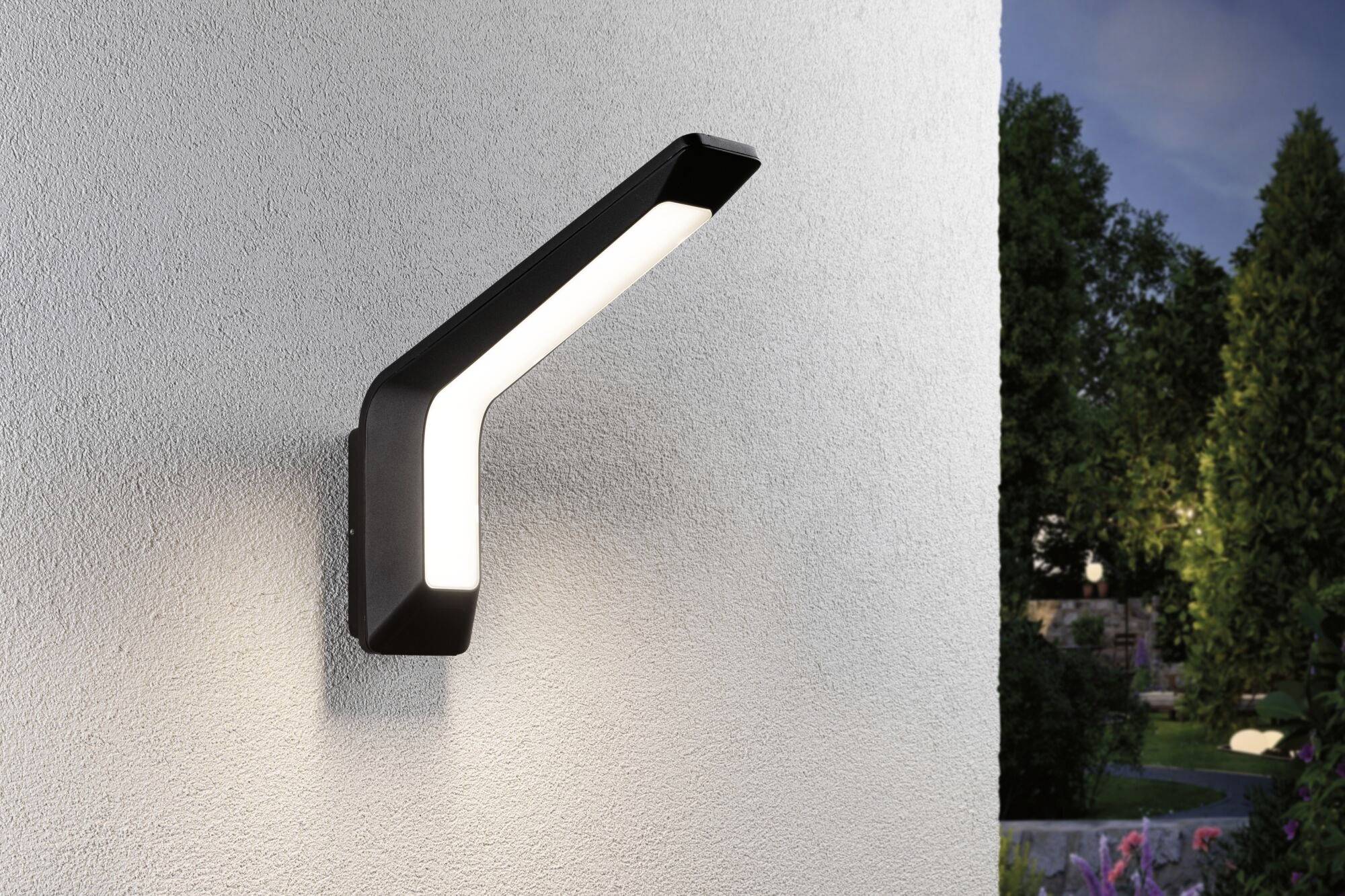 Nowoczesna lampa ścienna na elewacji o eleganckim, zakrzywionym kształcie, zamocowana na ścianie domu, oświetlająca przestrzeń na zewnątrz.