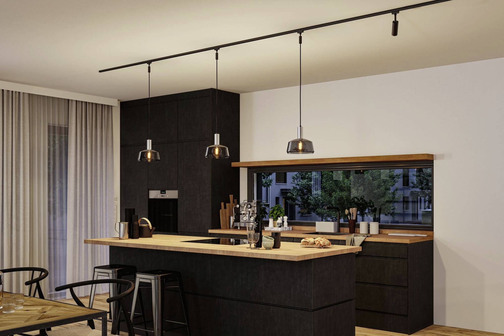 Nowoczesna kuchnia z ciemnymi szafkami, drewnianym blatem, stołkami barowym i wiszącymi lampami. W tle okno z widokiem na drzewa.