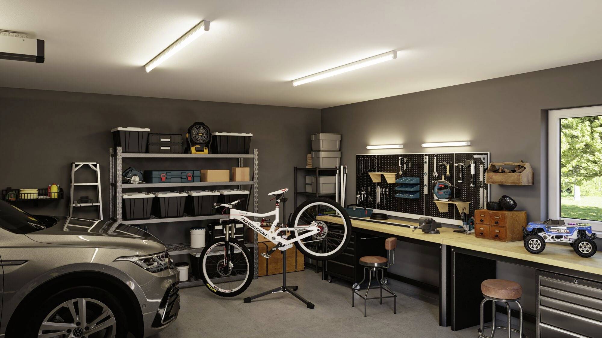 Zorganizowany garaż z samochodem po lewej stronie, rowerem na stojaku pośrodku i długim stołem roboczym po prawej stronie. W tle widoczne są regały z pudłami i narzędziami.