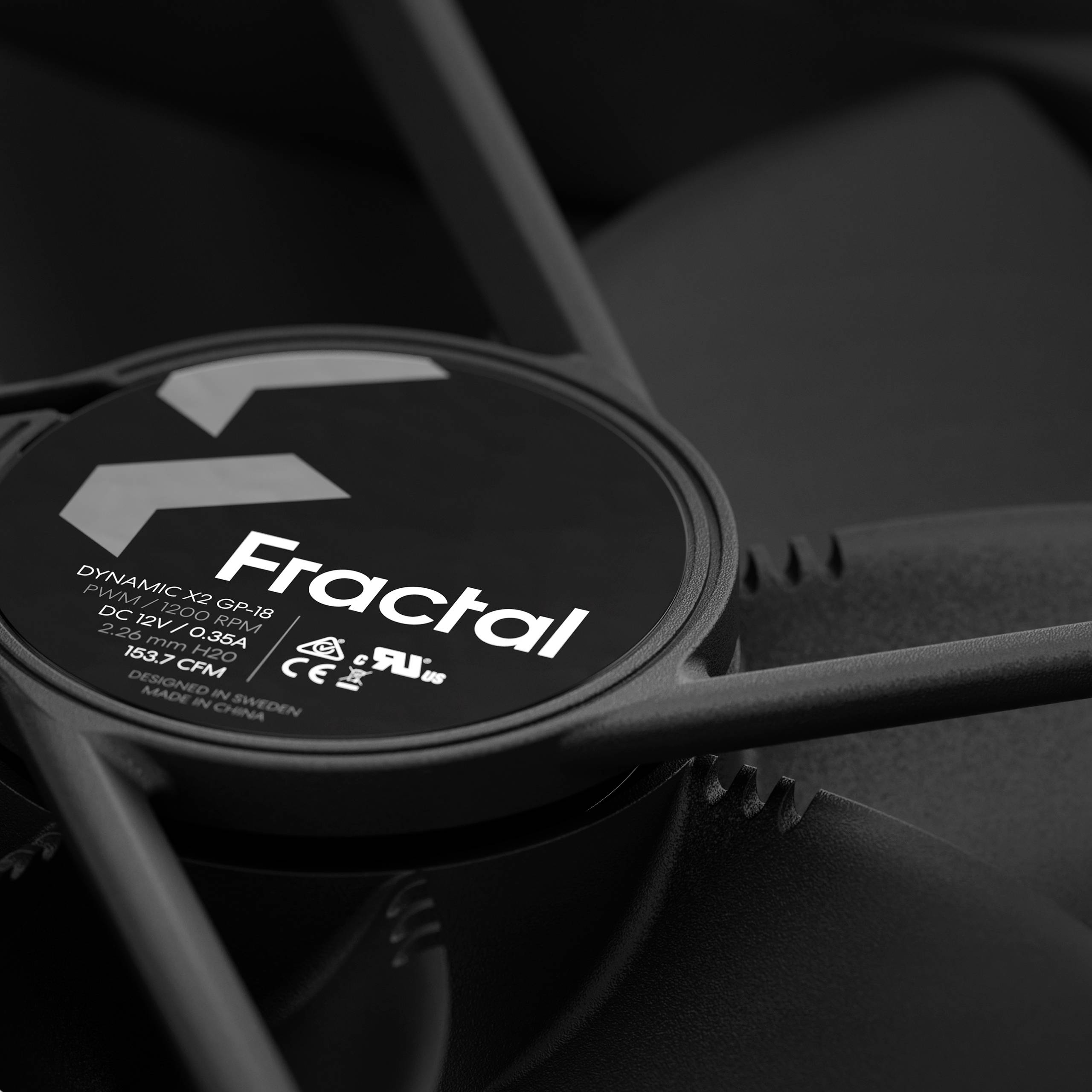 Logo 'Fractal' na czarnym wentylatorze komputerowym, ujęcie z bliska. Informacje o modelu i szczegóły techniczne są widoczne na etykiecie.