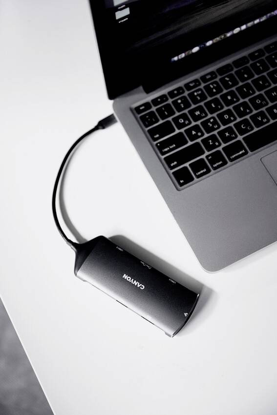 Laptop jest podłączony do zewnętrznego napędu za pomocą kabla.