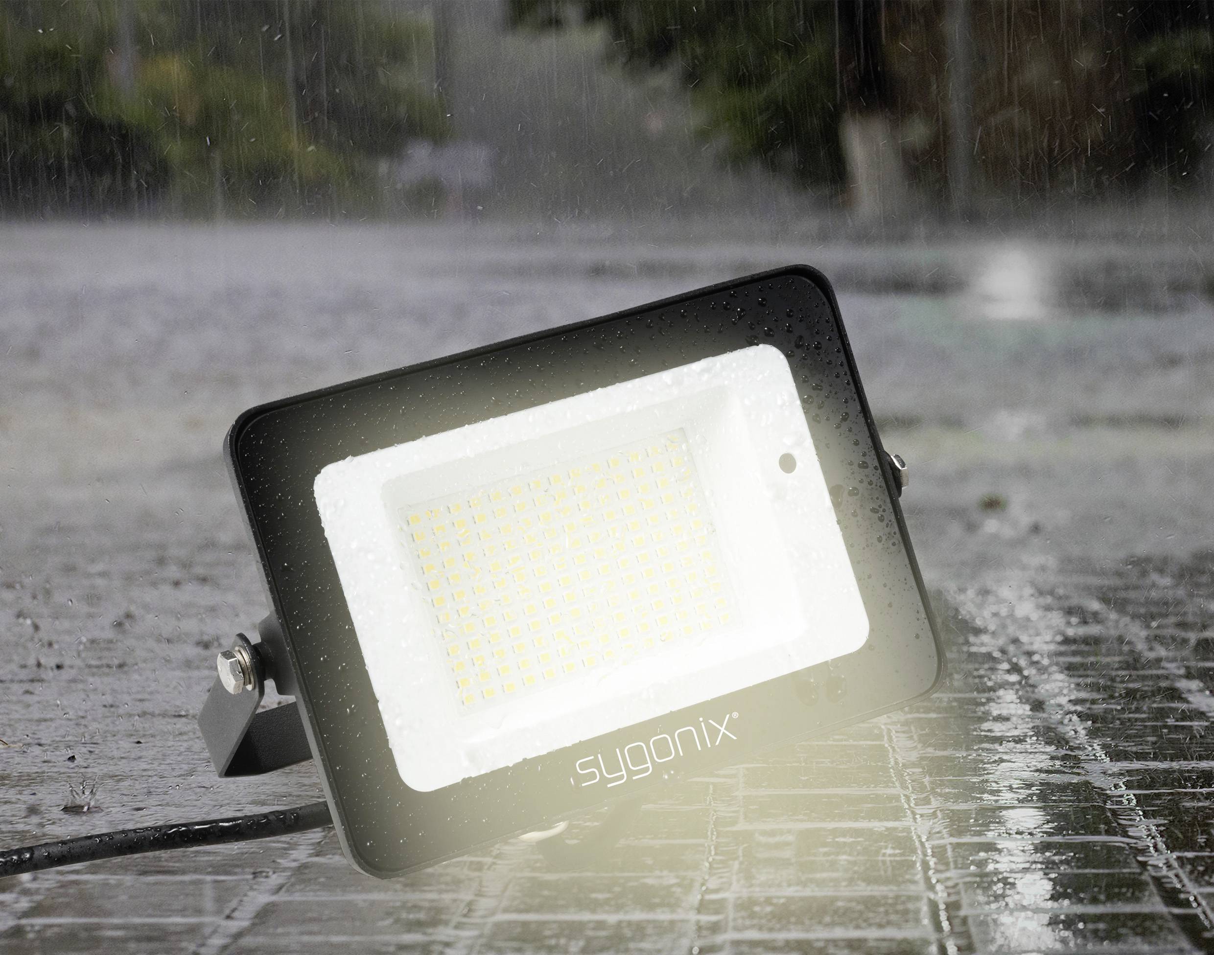 Reflektor LED świeci jasno na mokrej, deszczowej powierzchni. Światło demonstruje wytrzymałość w trudnych warunkach pogodowych.