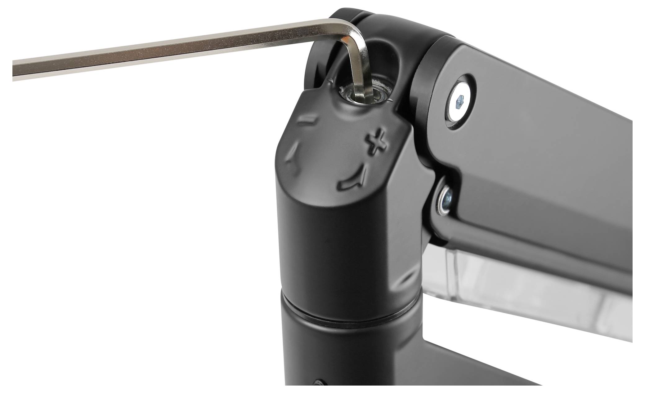 Zbliżenie mechanizmu przegubowego, gdzie klucz imbusowy reguluje śrubę. Widoczne są symbole '+' i '-'.