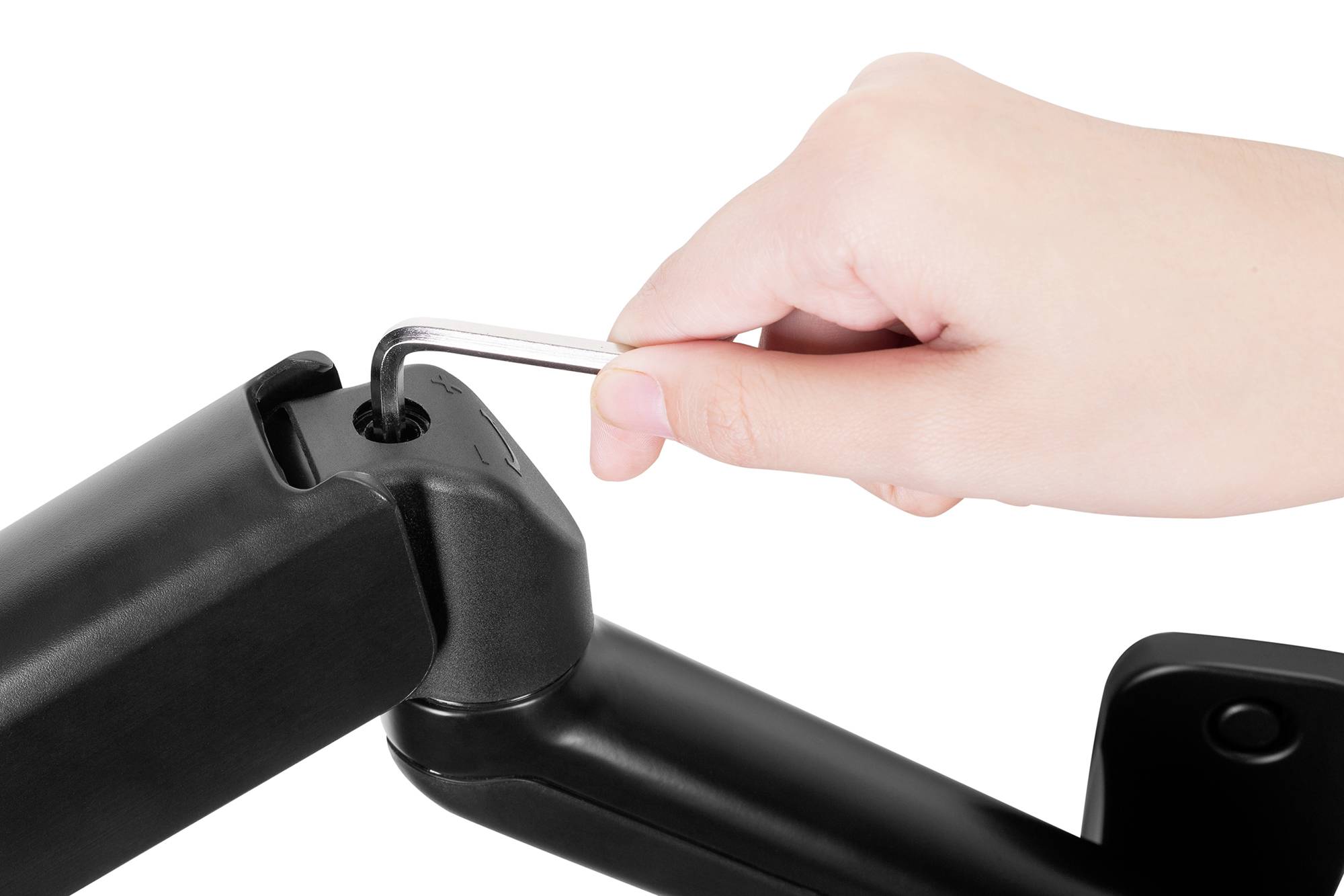 Ręka dokręca śrubę kluczem imbusowym na czarnym, regulowanym ramieniu.