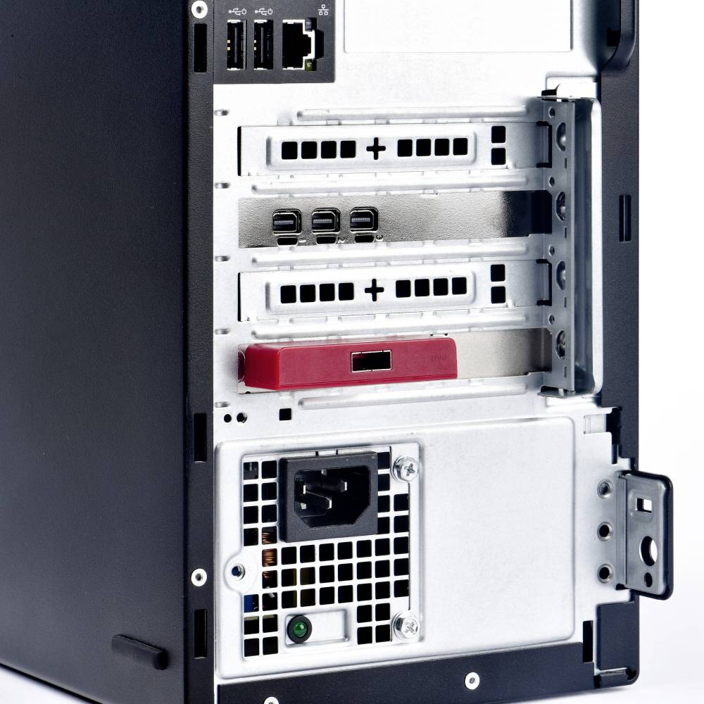 Obudowa komputera widziana od tyłu, ukazująca złącza takie jak USB i Ethernet, sloty rozszerzeń oraz otwory wentylacyjne.