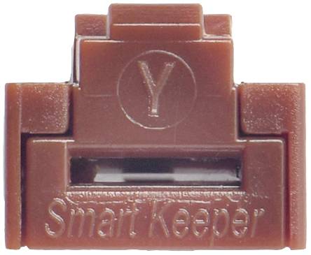 Brązowe plastikowe urządzenie o nazwie 'Smart Keeper' z symbolem Y na górze. Wygląda na zabezpieczenie do gniazda lub portu.