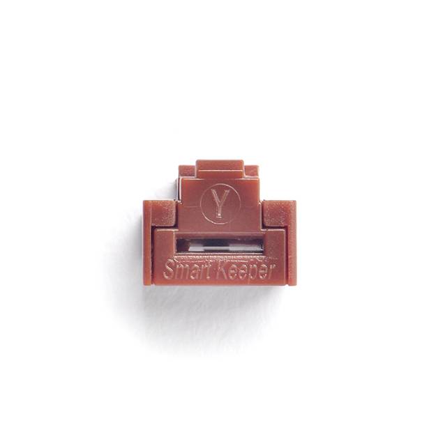 Brązowy, prostokątny obiekt plastikowy z napisem 'Smart Keeper', najprawdopodobniej zabezpieczenie lub osłona portu USB.