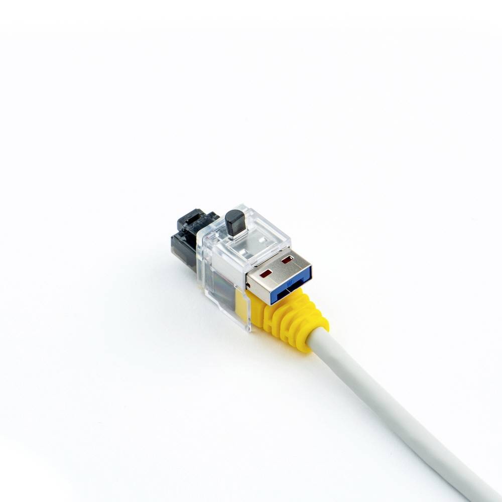 Kabel sieciowe Ethernet z przezroczystą wtyczką leży na białym tle.