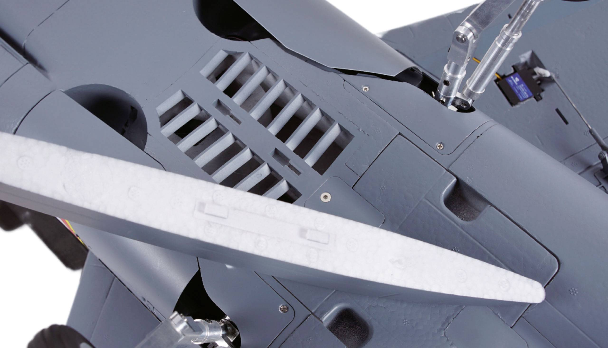 Zbliżenie modelu samolotu ukazuje skrzydła i elementy podwozia. Szczegółowy widok struktury powierzchni.