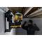Mężczyzna wyrównuje strukturę za pomocą zielonego lasera poziomującego firmy Dewalt. Urządzenie jest zamocowane na ścianie.