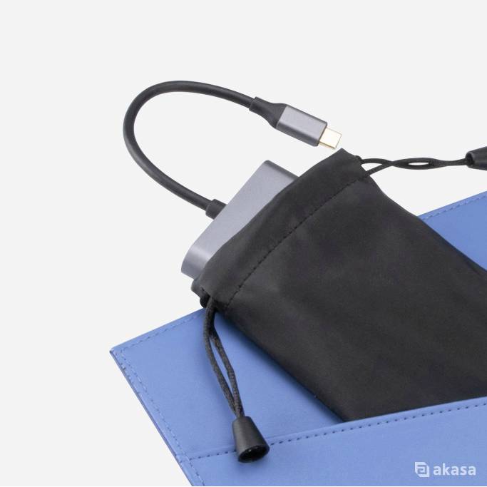 Przenośna ładowarka jest częściowo wyciągana z czarnej torby. Przewód USB jest podłączony.