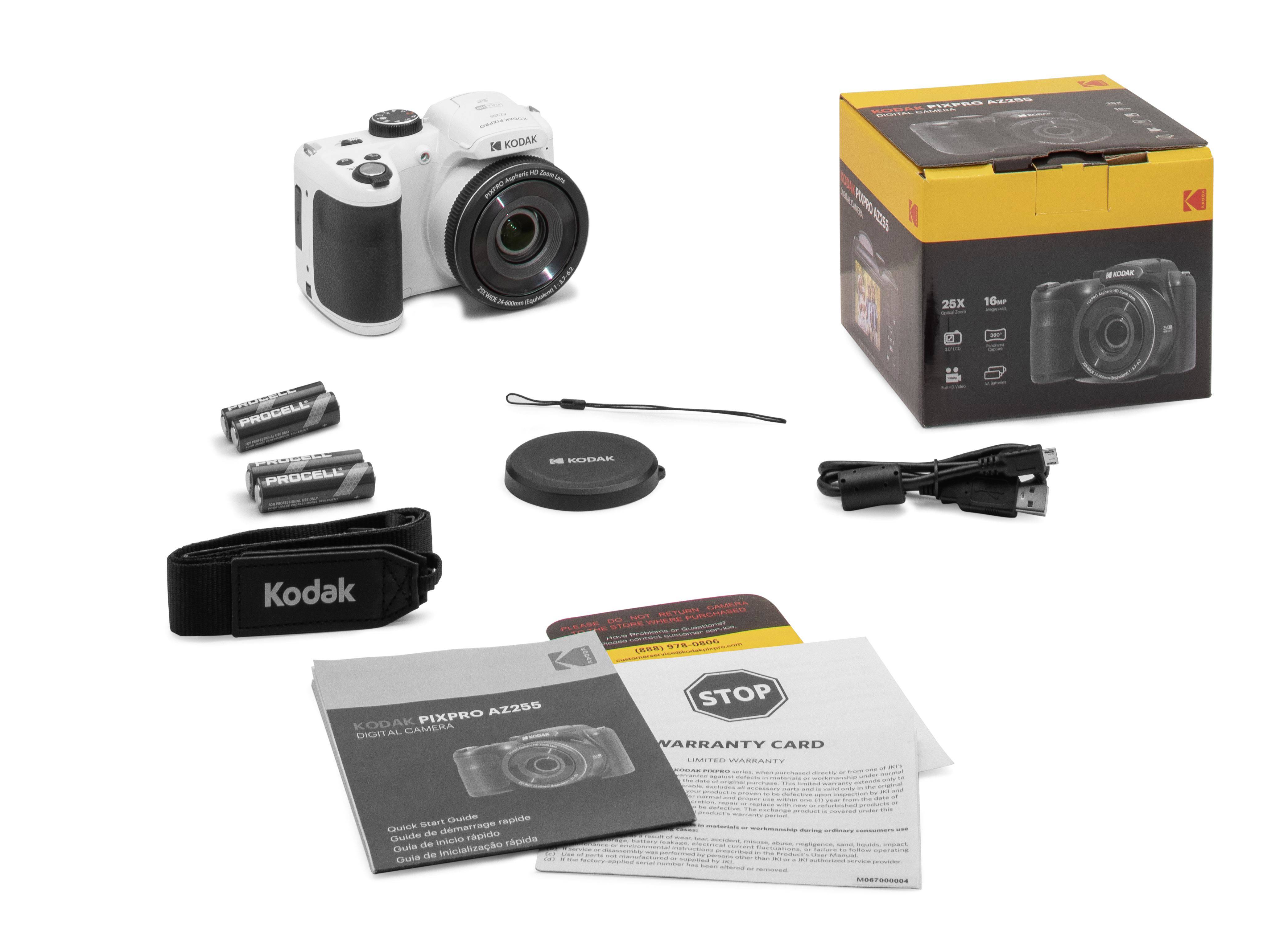 Cyfrowy aparat fotograficzny z akcesoriami: bateriami, dekielkiem obiektywu, paskiem na ramię, kablem USB i instrukcją obsługi na tle opakowania.