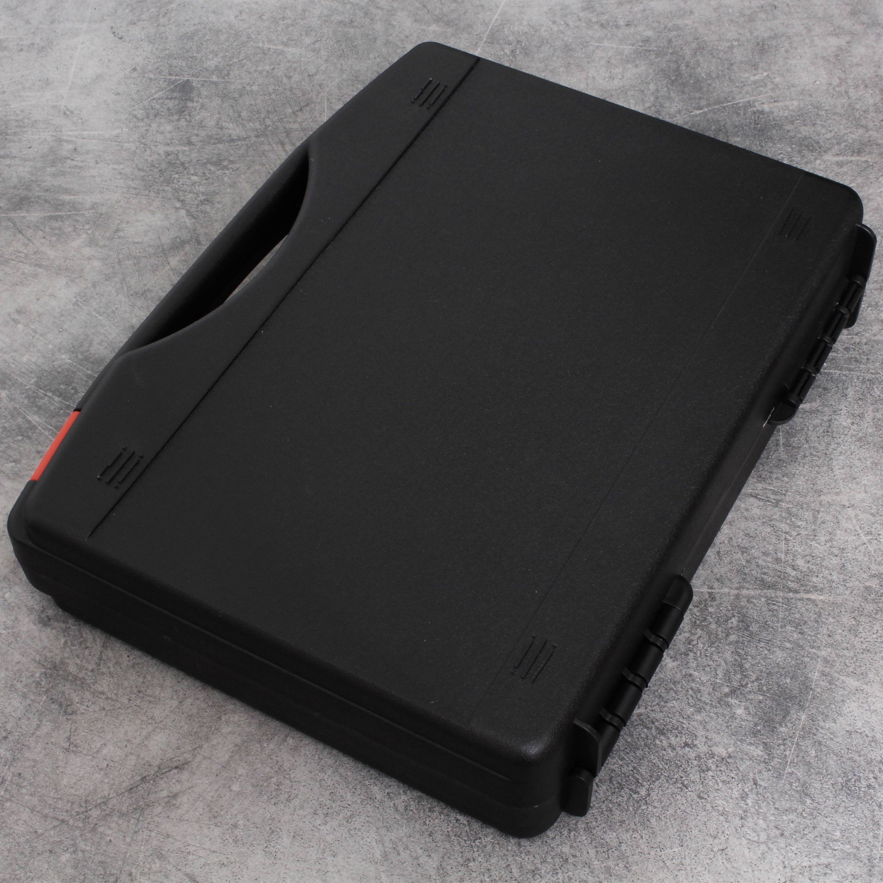 Zamknięta, czarna plastikowa walizka z czerwonym zamknięciem leży na szarym tle.