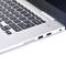 Srebrny laptop z czarną klawiaturą, widziany z boku. Widoczne są złącza USB i zasilania.