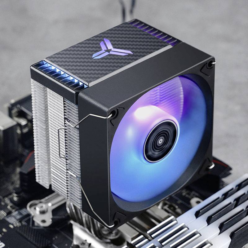 Chłodnica procesora komputerowego na płycie głównej, z dużym wentylatorem pośrodku, świecącym niebiesko-fioletowym światłem.