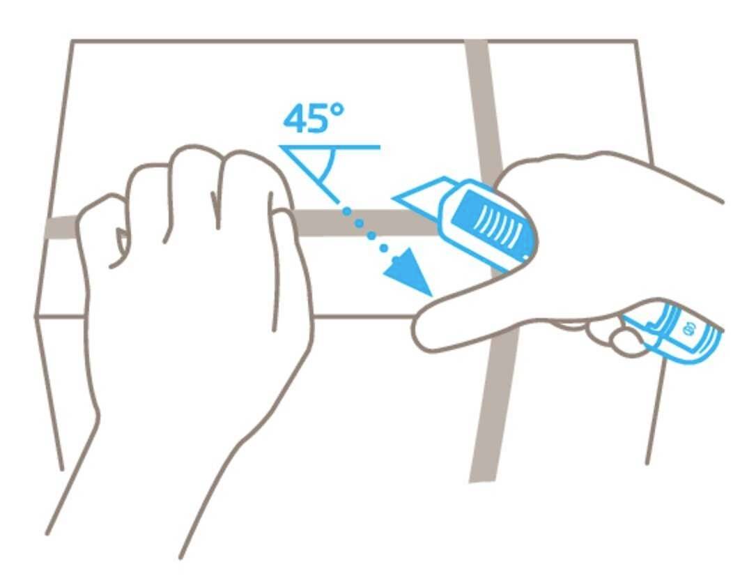 Jedna ręka trzyma karton. Inna ręka nacina nożem wzdłuż krawędzi kartonu pod kątem 45 stopni.