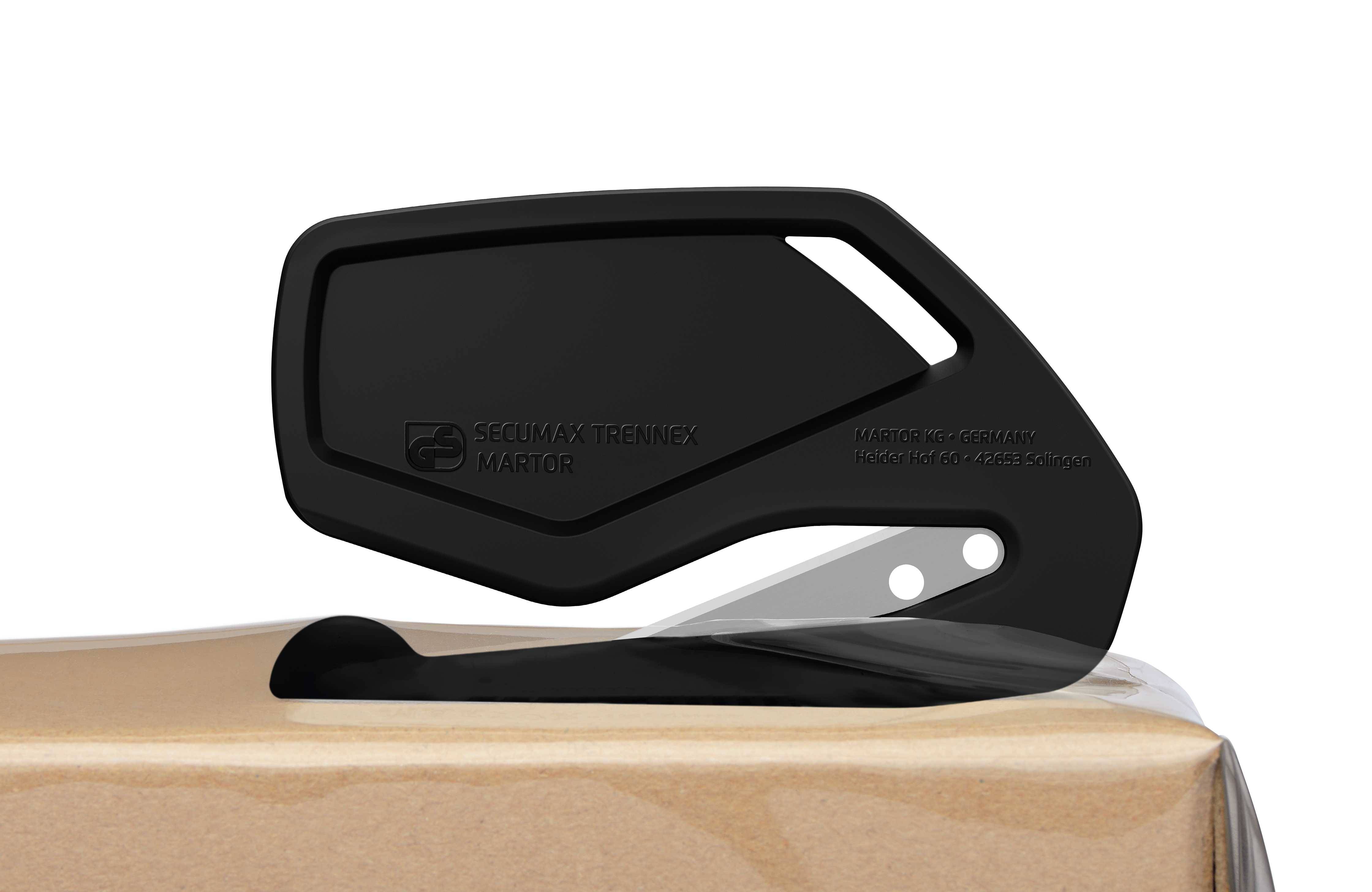 Czarny nóż bezpieczeństwa przecina taśmę pakową na kartonie. Nacisk położony jest na bezpiecznym użytkowaniu.