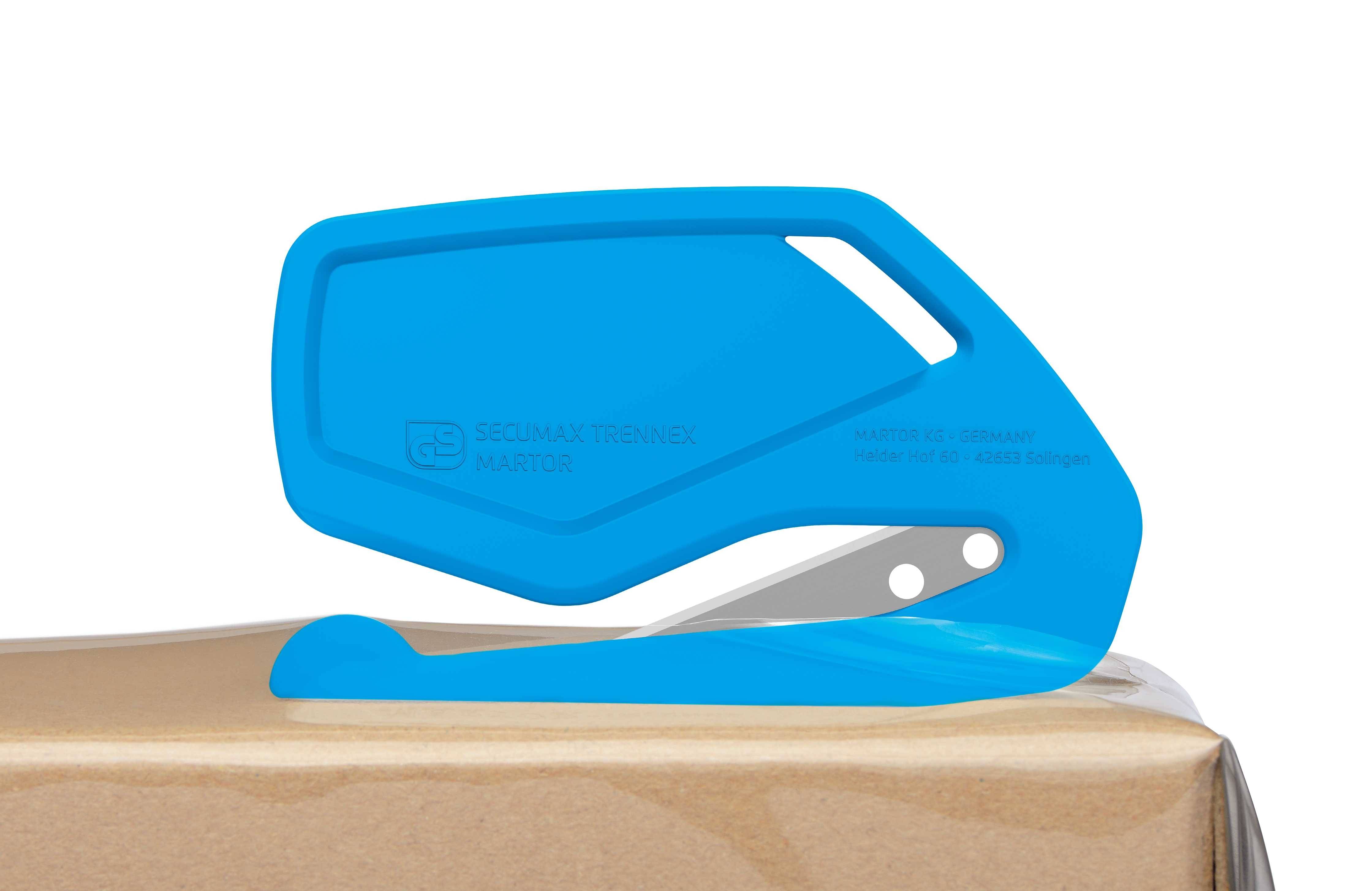 Niebieski otwieracz bezpieczeństwa na kartonie. Urządzenie posiada zakrzywione ostrze do cięcia opakowań kartonowych.
