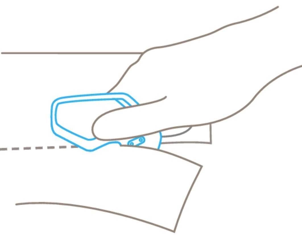 Jedna ręka trzyma kredowy znacznik krawieckich i zaznacza linię przerywaną na kawałku materiału.