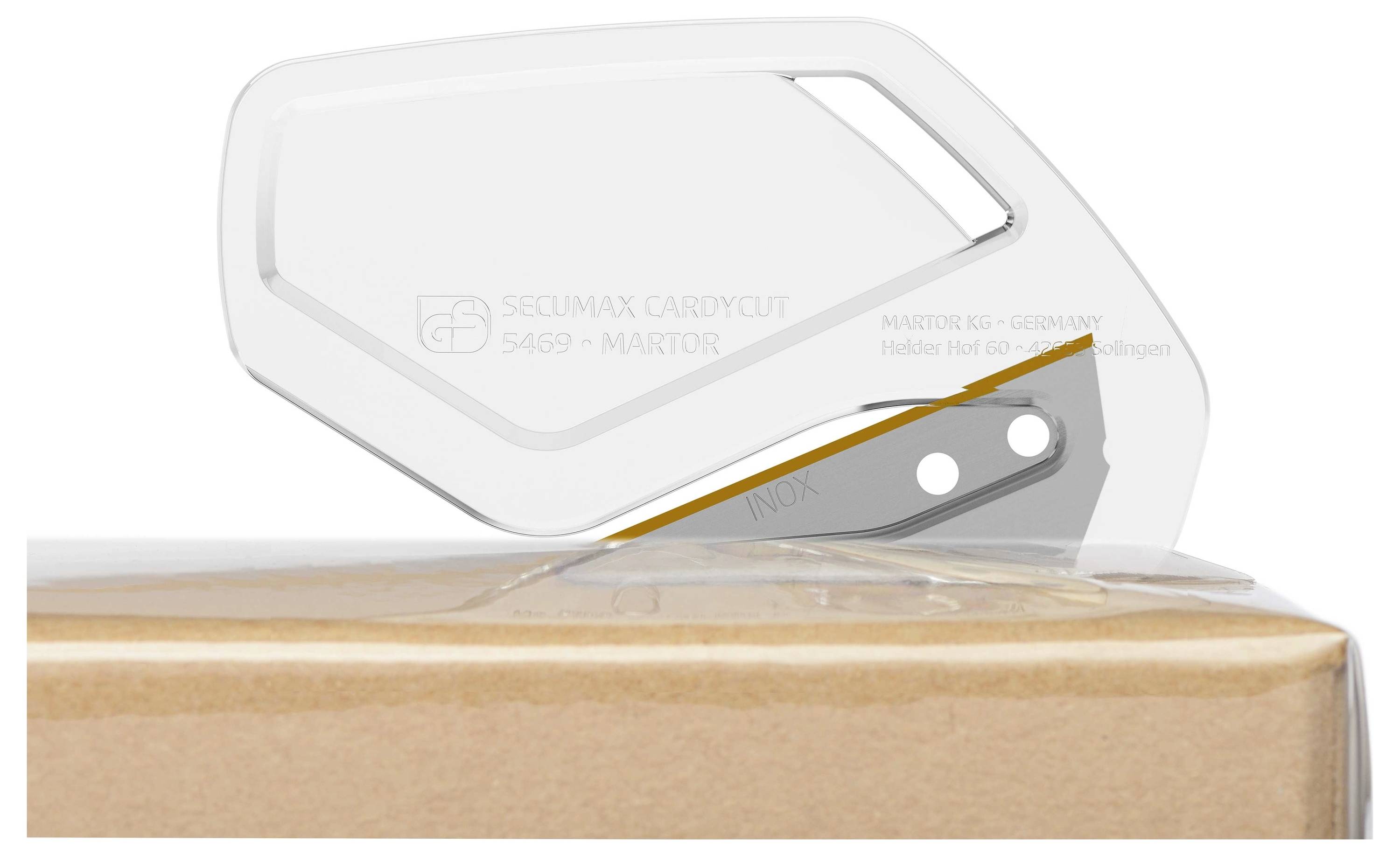 Nóż bezpieczny przecina pudełko kartonowe. Nóż posiada przezroczystą osłonę ochronną i ostrą klingę.