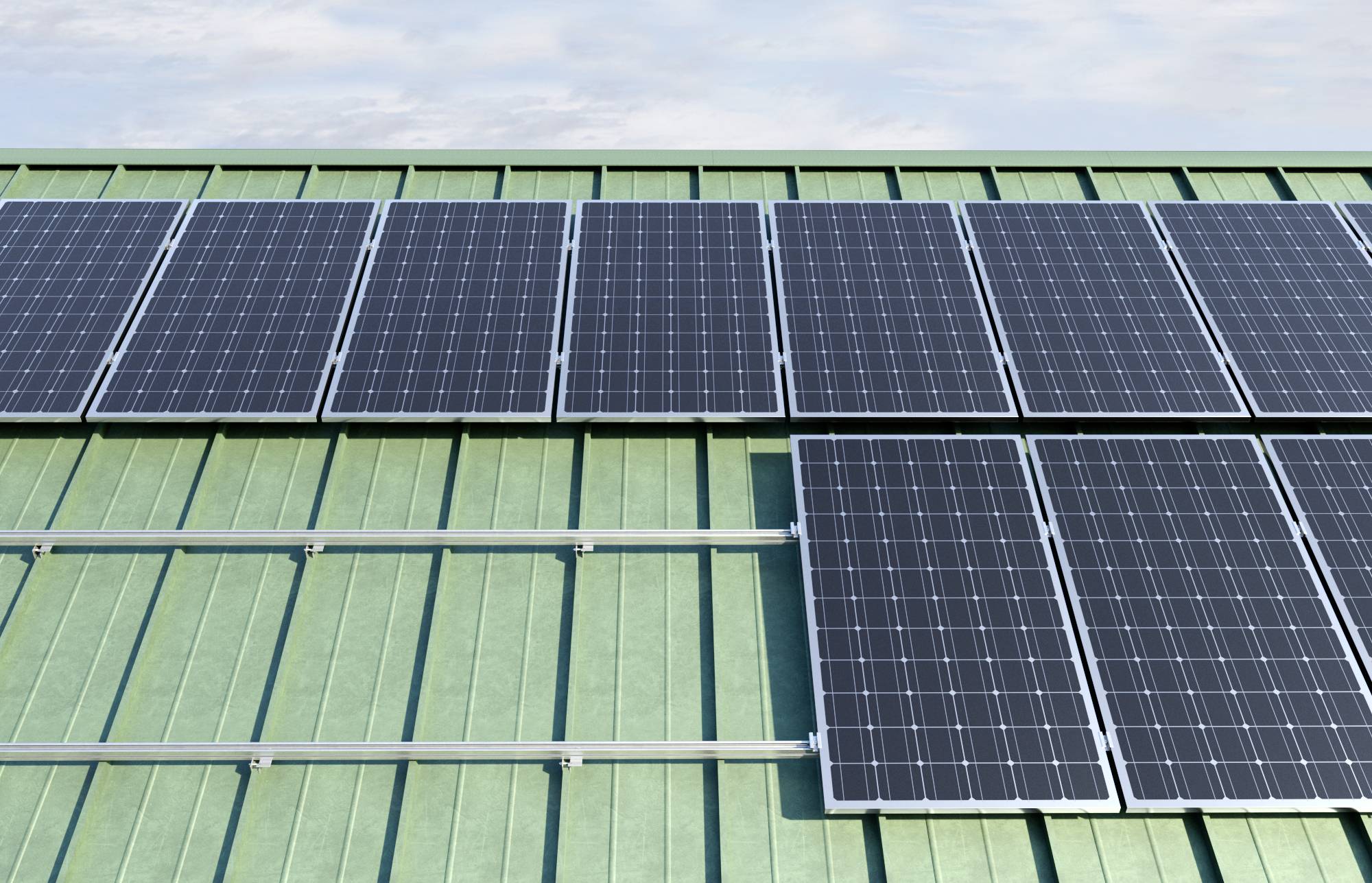 Panele słoneczne na zielonym metalowym dachu pod pochmurnym niebem, wykorzystujące energię słoneczną do zrównoważonej produkcji energii elektrycznej.