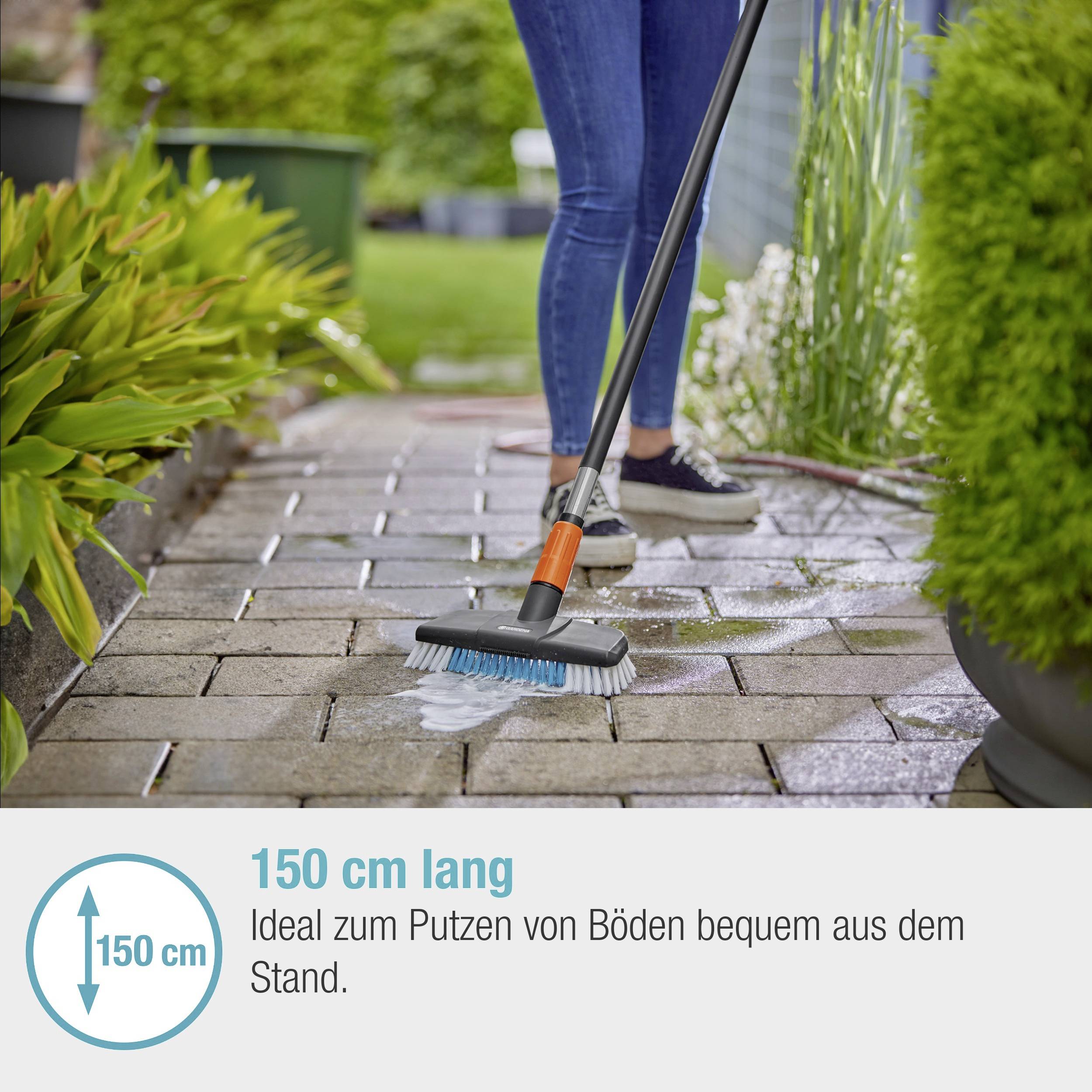 Osoba czyści podłogę na wolnym powietrzu szczotką na długim drążku. Tekst na obrazku: '150 cm długości. Idealna do czyszczenia podłóg wygodnie, bez schylania się.'