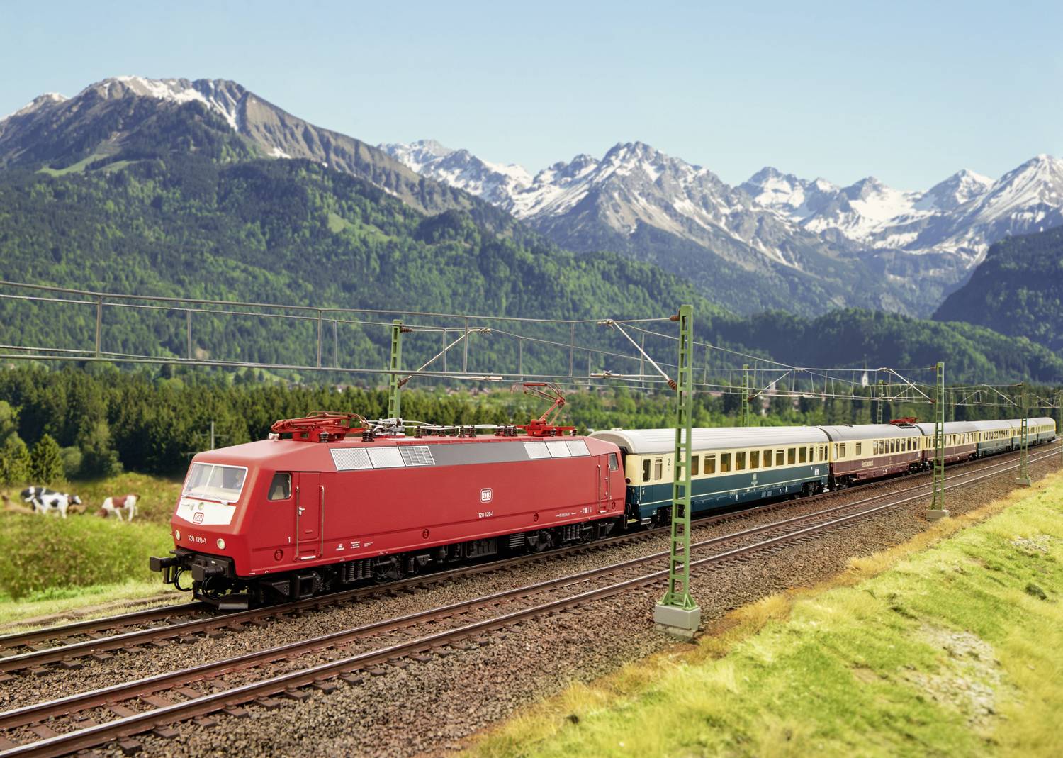 Czerwony pociąg jedzie przez zieloną krajobraz z górami w tle. Czyste niebo, wyraźny widok na góry i roślinność.