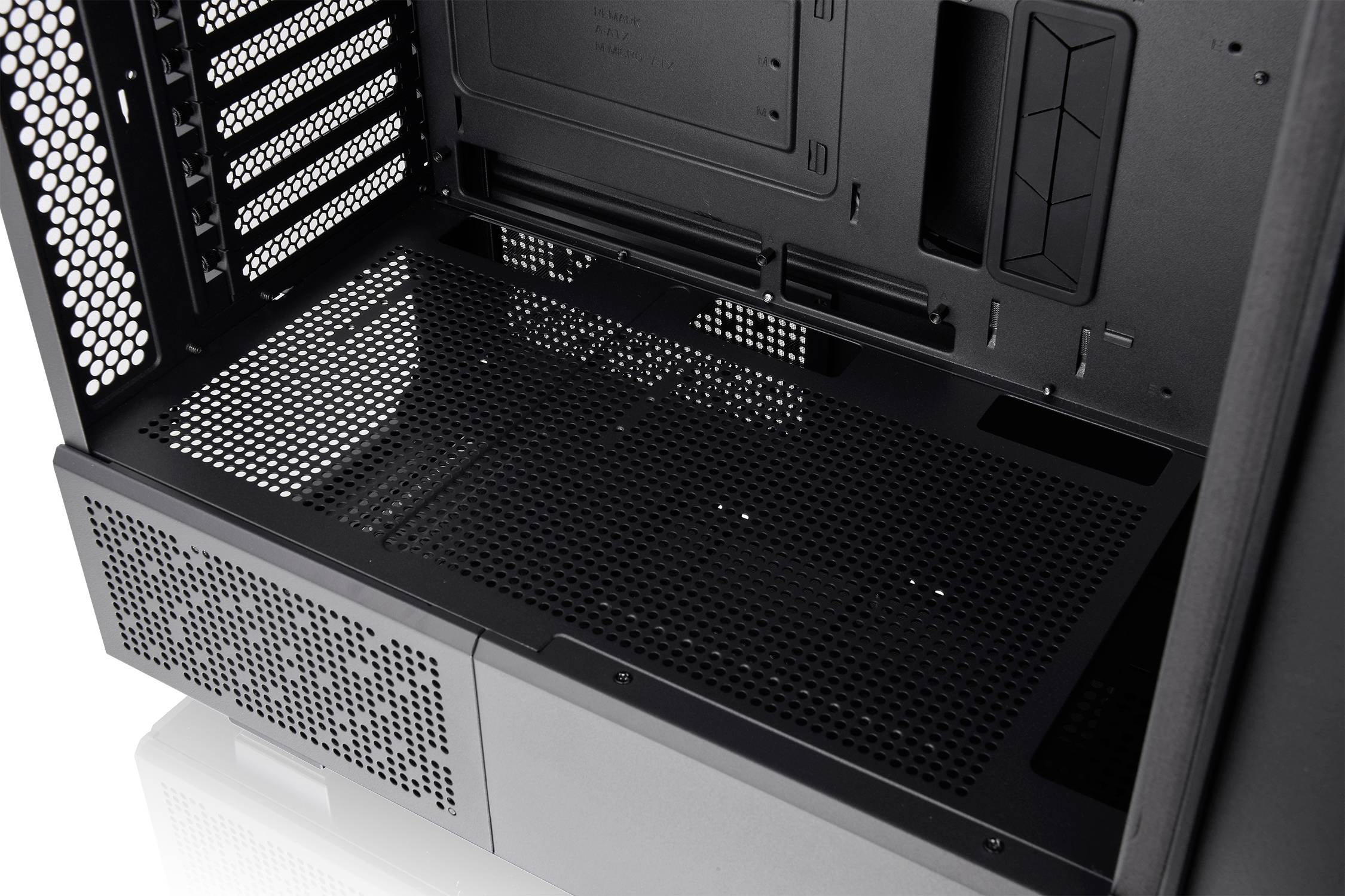 Pusta obudowa komputerowa z czarną, otwartą przestrzenią wewnętrzną, kratkami wentylacyjnymi i miejscem na montaż podzespołów.