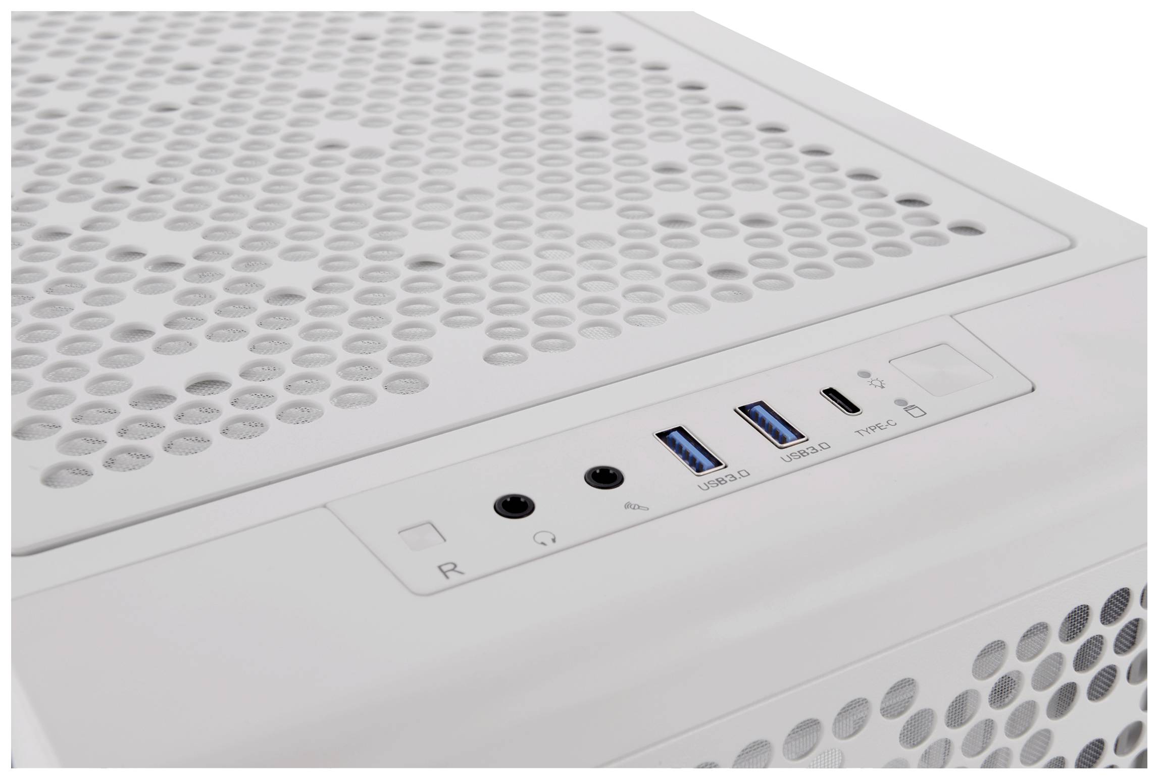Zbliżenie białej obudowy komputera z wieloma otworami wentylacyjnymi na górnej powierzchni oraz różnymi portami, w tym złączami USB i gniazdami audio.
