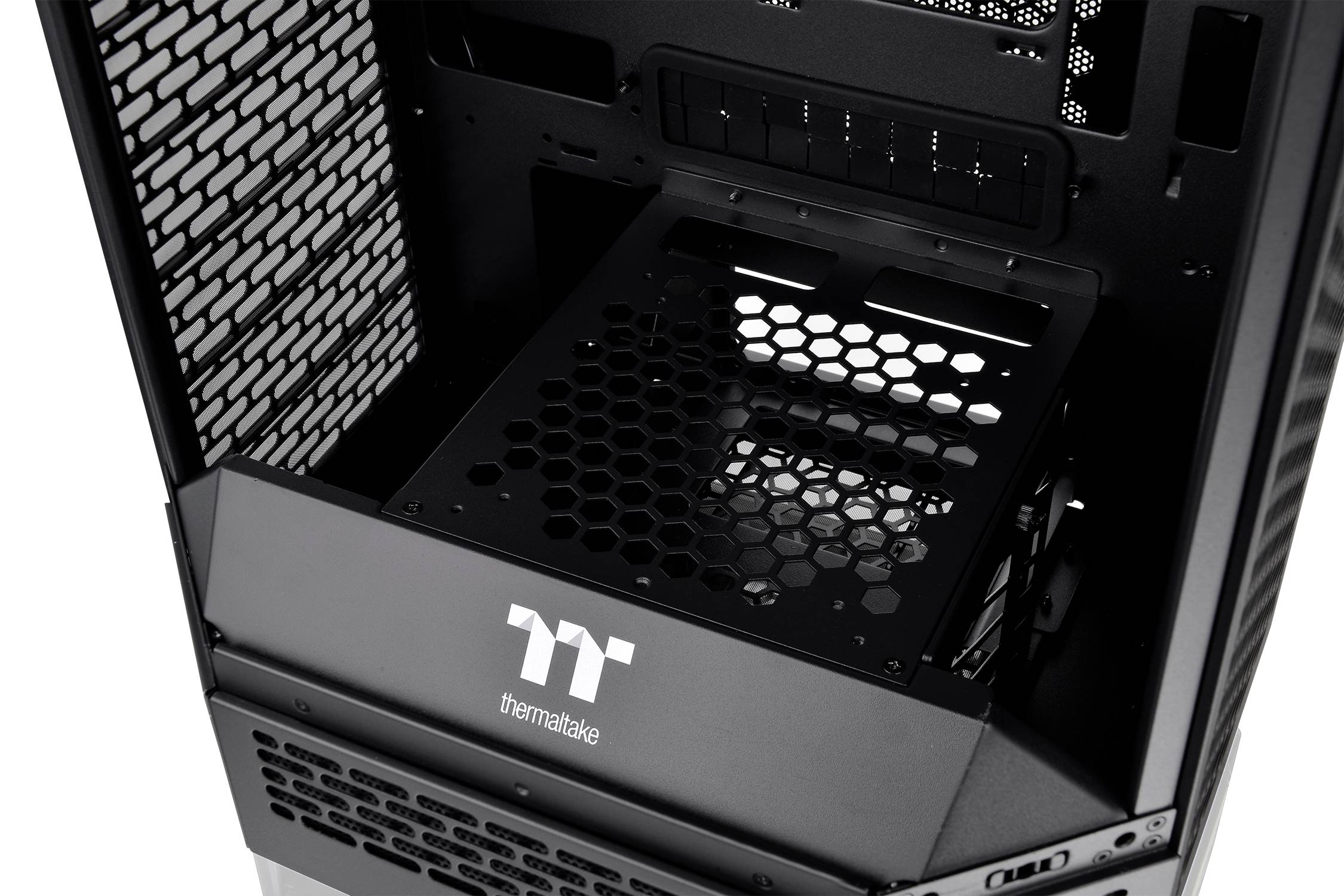 Obudowa komputera PC firmy Thermaltake z odsłoniętym wnętrzem, prezentująca kieszeń na napędy oraz kratkę wentylacyjną.