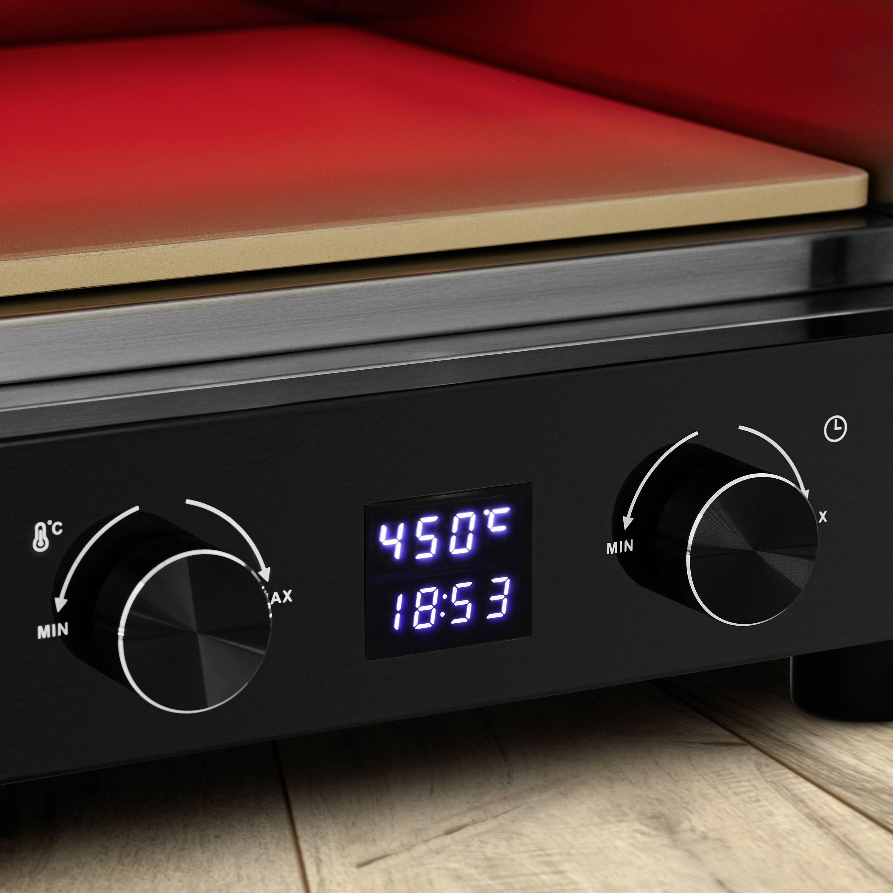 Zbliżenie czarnej sterownicy piekarnika z dwoma pokrętłami, cyfrowym wyświetlaczem temperatury (450°C) oraz godziną (18:53).