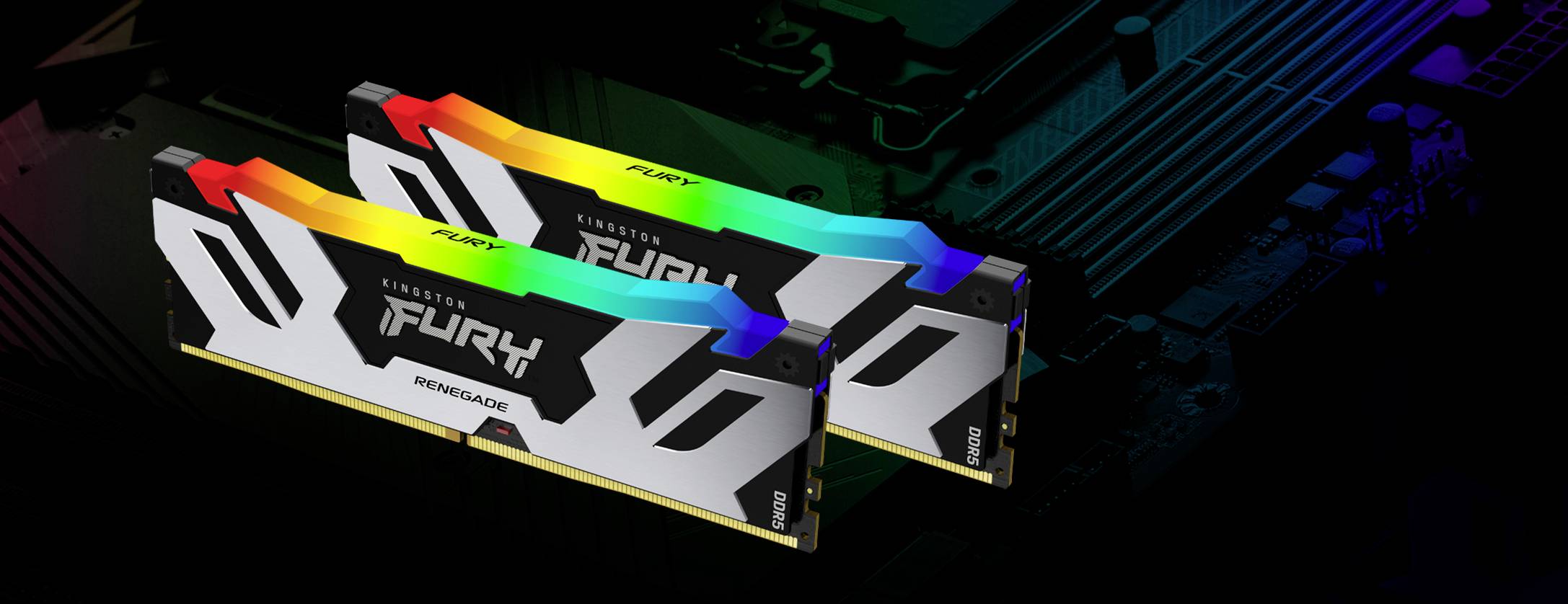 Dwa moduły RAM z podświetleniem RGB w komputerze. Są oznaczone napisem 'Fury Renegade' i zamontowane na płycie głównej.