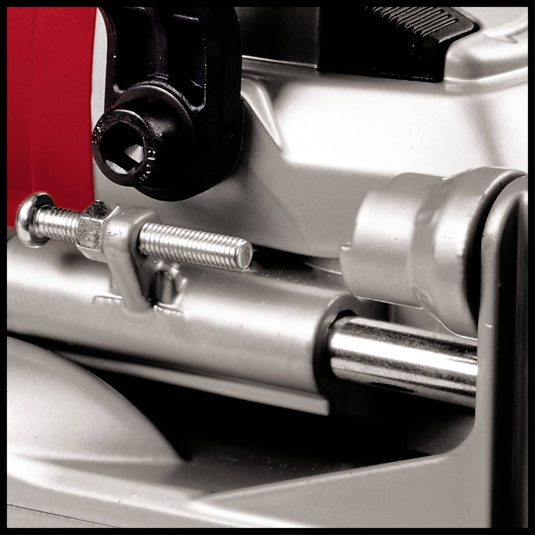 Zbliżenie metalowej maszyny z śrubami i dźwignią, prawdopodobnie fragment narzędzia lub urządzenia mechanicznego.