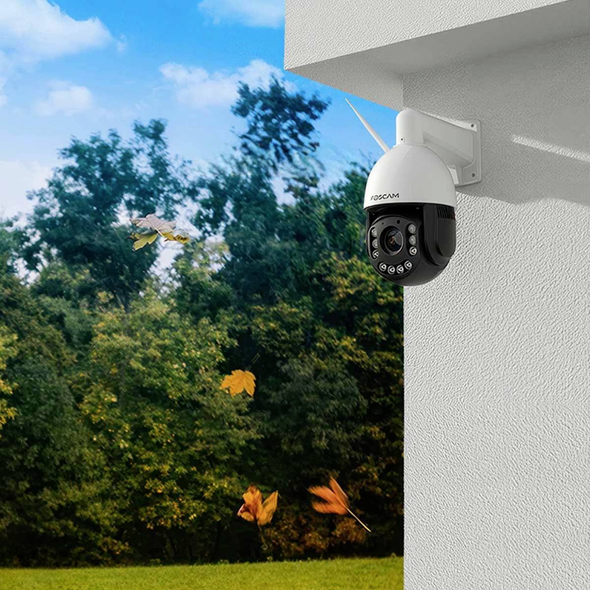 Kamera monitorująca jest zainstalowana na rogu budynku i nadzoruje przylegający teren leśny w ciągu dnia.