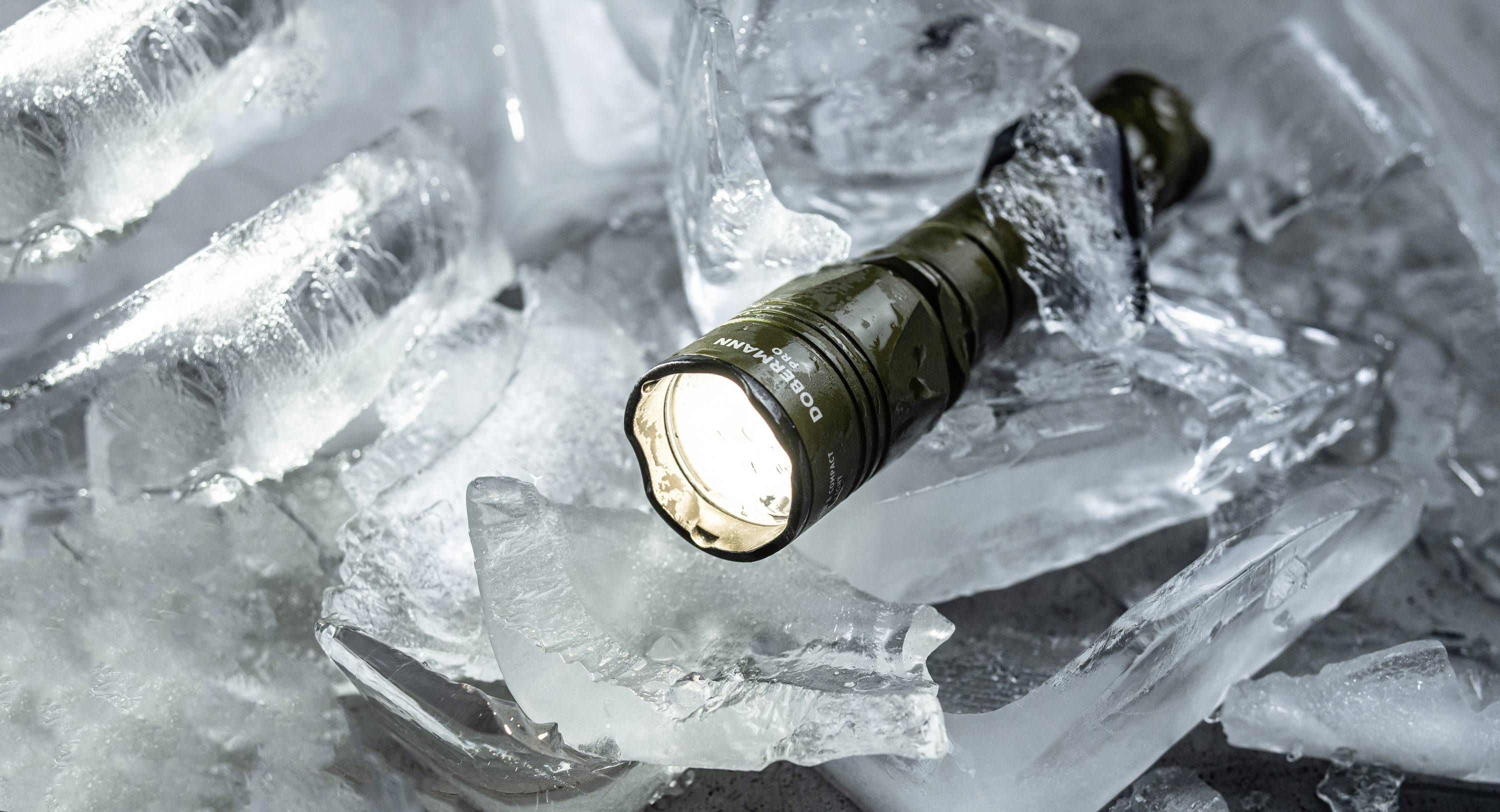 Włączona latarka leży na potłuczonych kawałkach lodu i oświetla otoczenie.