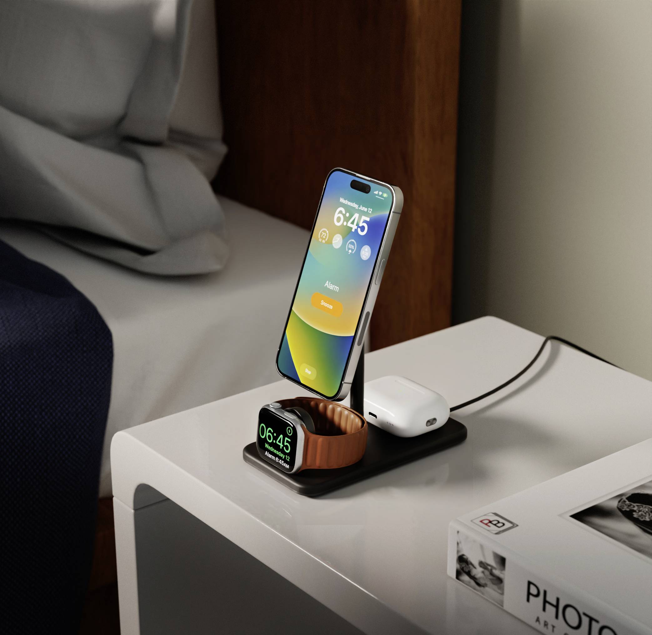 Smartfon ładuje się na podstawce nocnej szafki obok łóżka. Smartwatch wskazuje godzinę 6:45. Ładowarka i słuchawki są również widoczne.