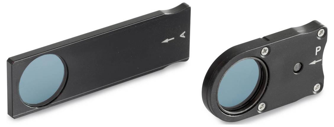 Dwa prostokątne czarne filtry ze szkłem w kolorze niebieskim i oznaczeniami strzałek na powierzchni, ustawione zgodnie z kierunkiem soczewek.