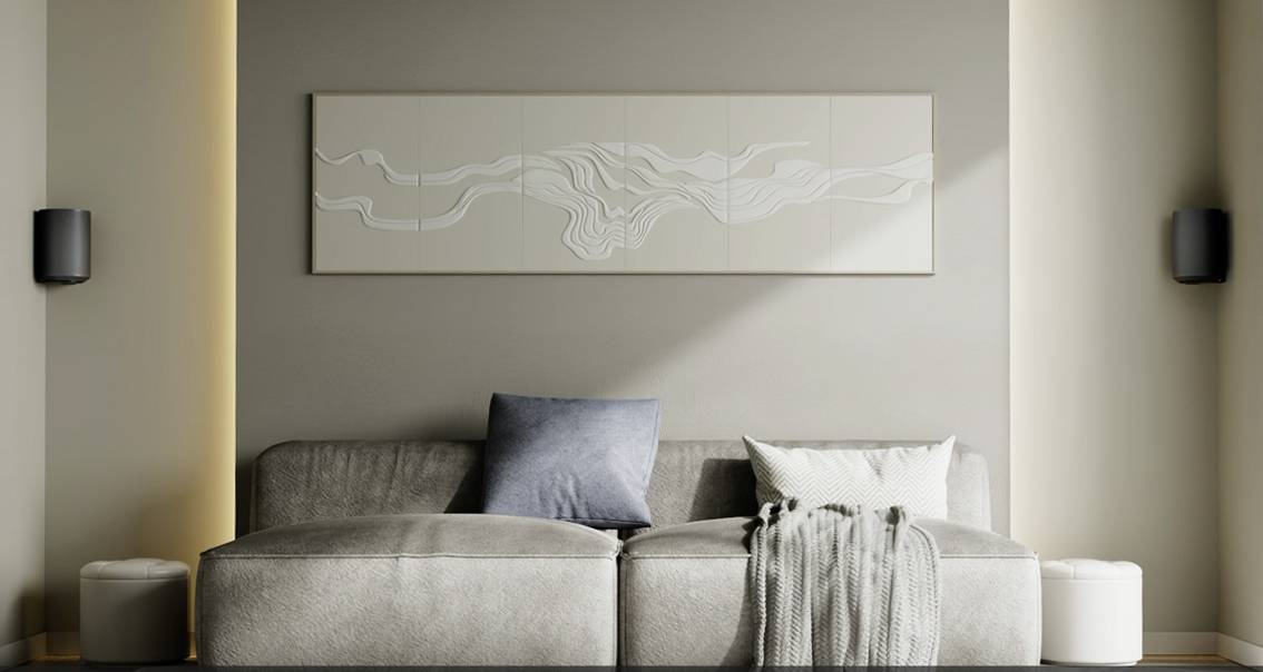 Nowoczesny salon z szarą sofą, ozdobioną białymi i szarymi poduszkami. Na ścianie wisi abstrakcyjne dzieło sztuki.