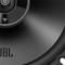 Zbliżenie głośnika o błyszczącej powierzchni z logo 'JBL' w dolnej części.