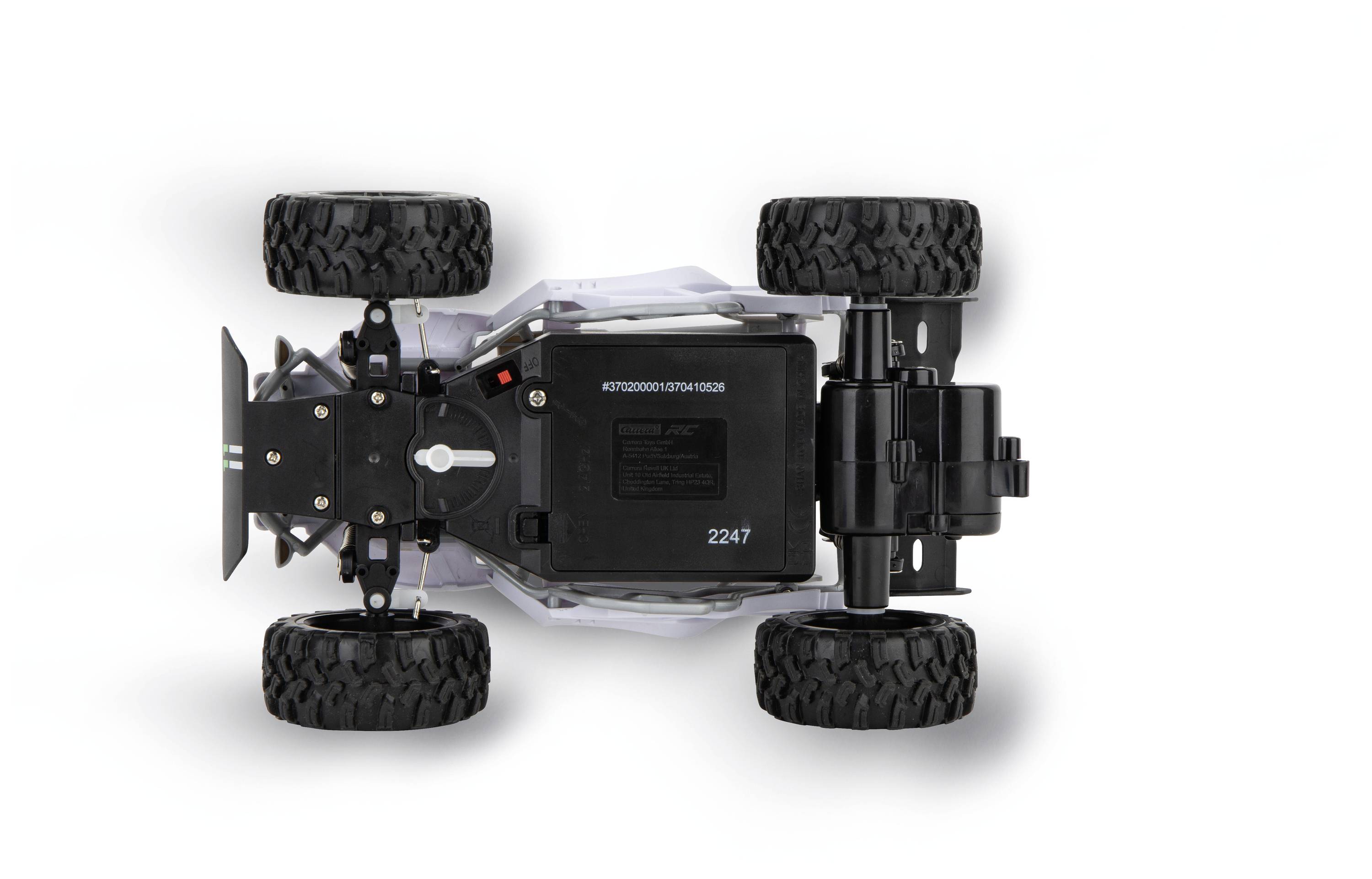 Zdalnie sterowany samochód widziany z góry na białym tle. Duże terenowe opony, solidna budowa, widoczna komora baterii.