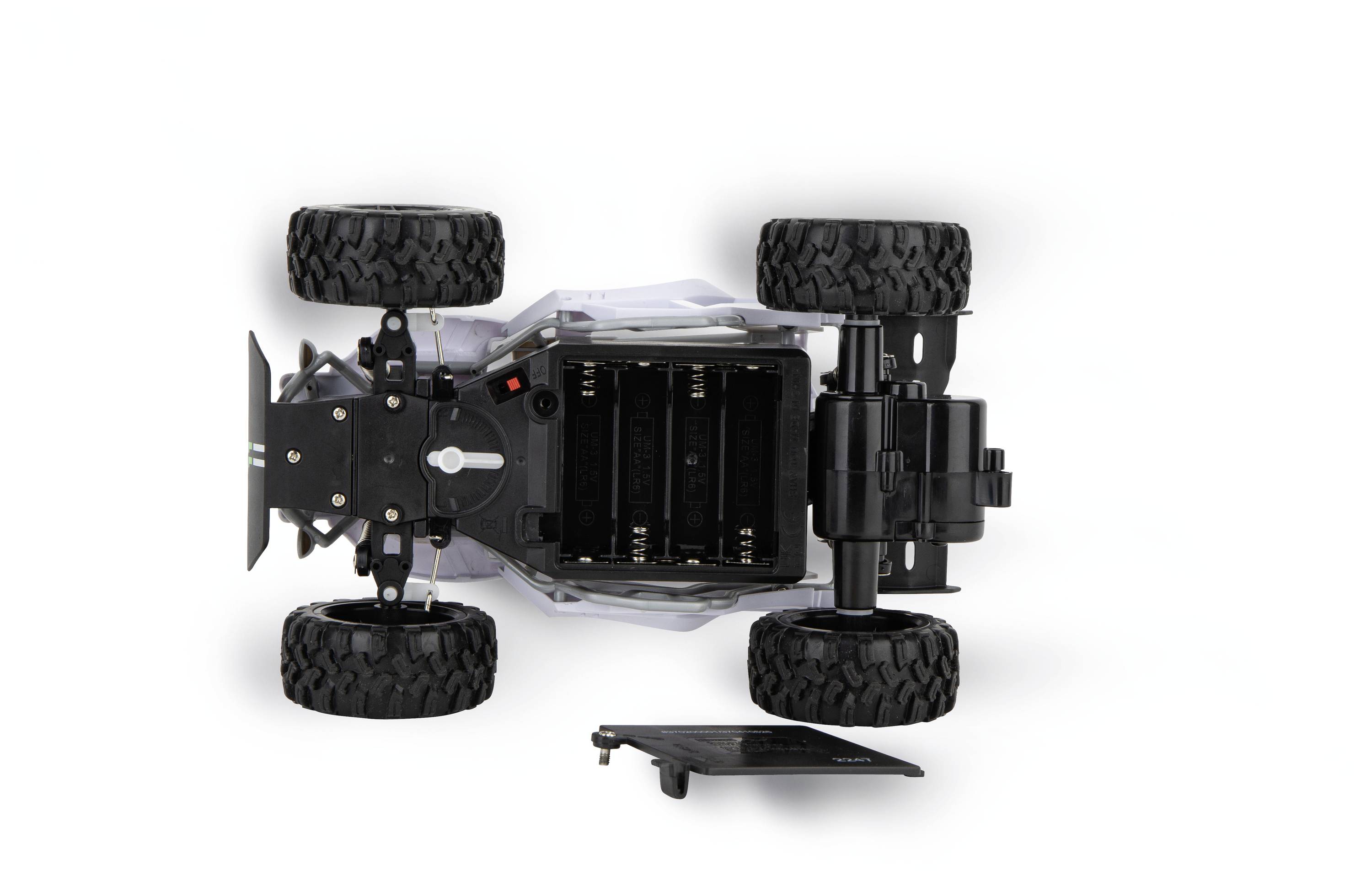 Zabawkowy samochód widziany z góry z odkrytymi pokrywami baterii. Widok na komory bateryjne i duże, terenowe opony.