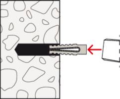 Diagram przedstawia kołek rozporowy wprowadzony w otwór w ścianie wykonanej z nieregularnego materiału. Strzałka wskazuje na kołek.