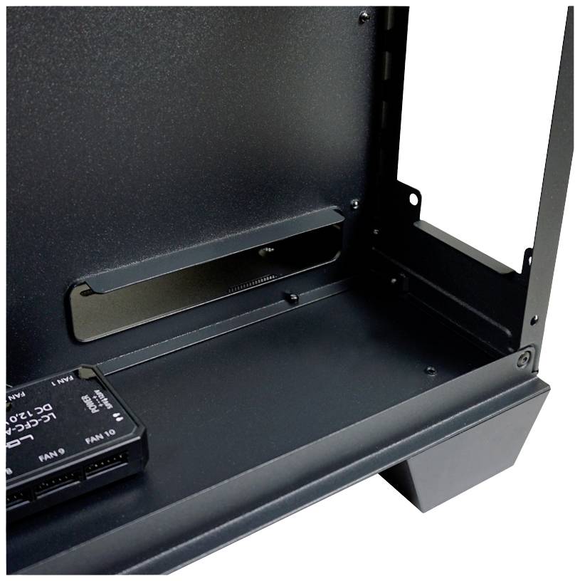 Widok wewnętrzny obudowy komputera z modułem sterowania wentylatorem w lewym dolnym rogu oraz prostokątnym przepustem kablowym pośrodku.