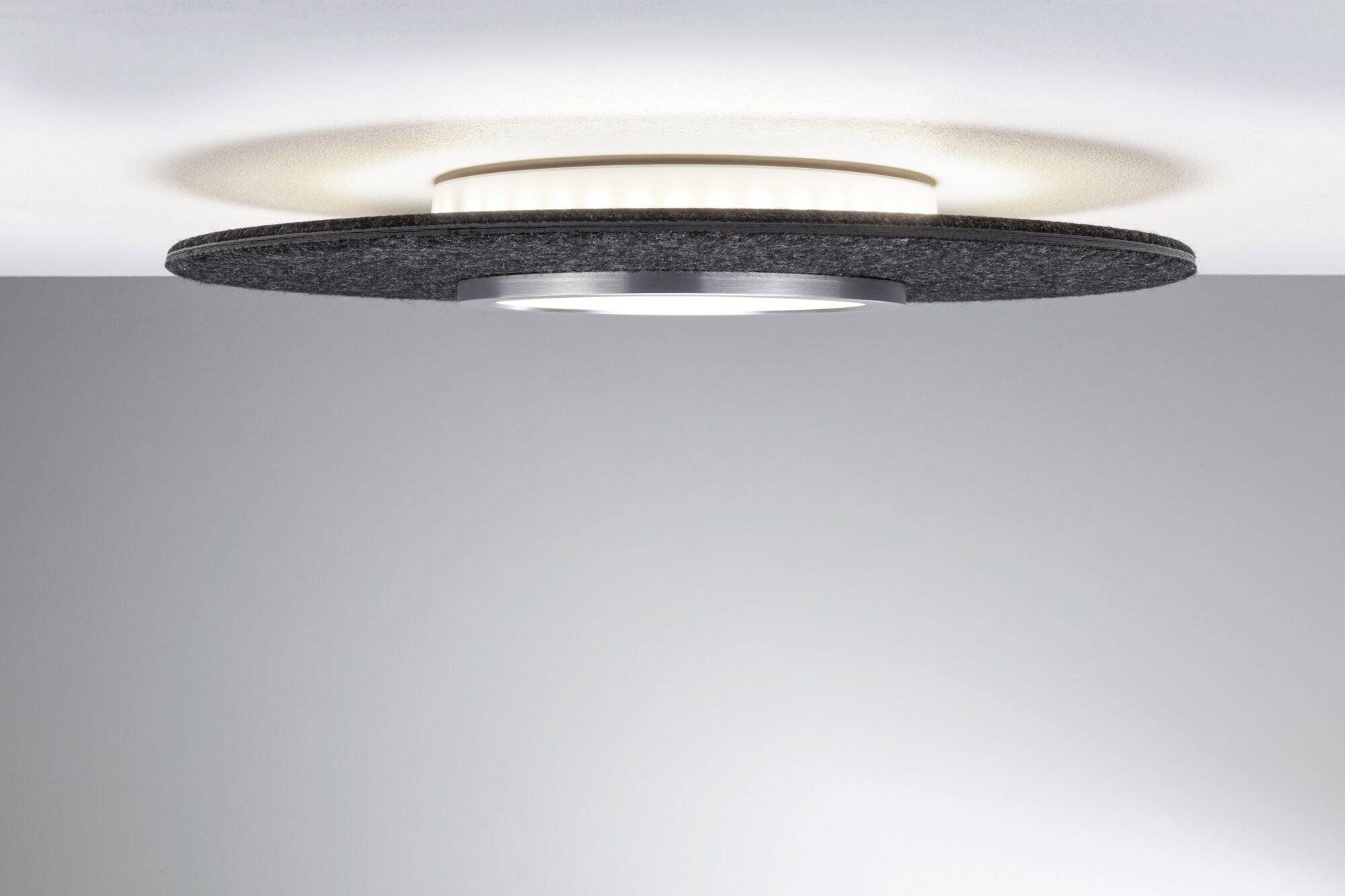 Okrągła lampa sufitowa z czarną obwódką i centralnym, świecącym elementem. Nowoczesny, minimalistyczny design.